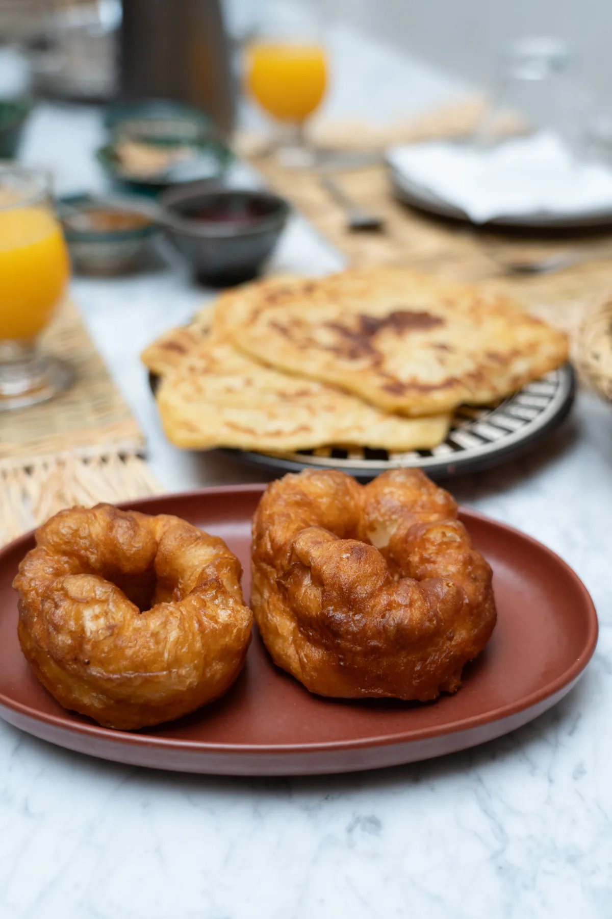 Buñuelos sfenj y crepes marroquíes en una bandeja de desayuno